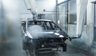 Car body being painted in a manufacturing facility 